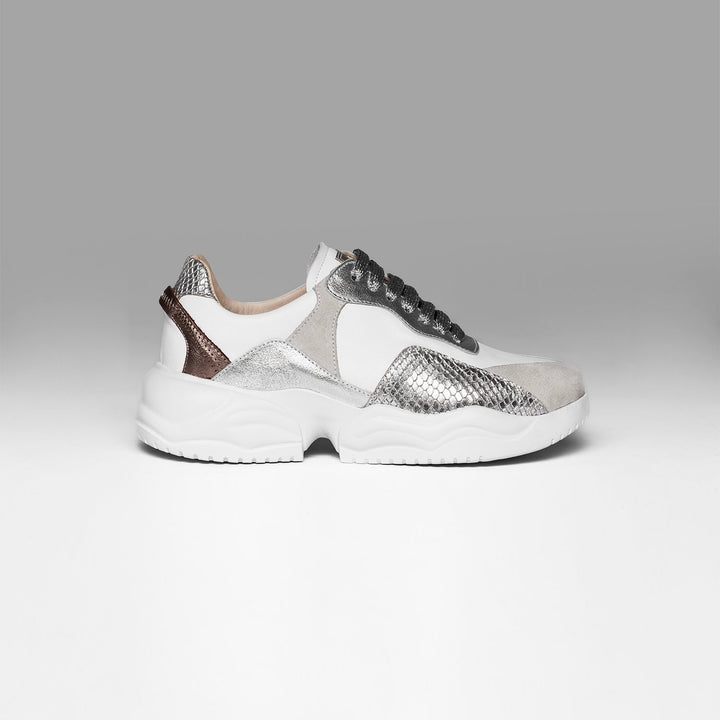 Silver and white sneaker on a gray background